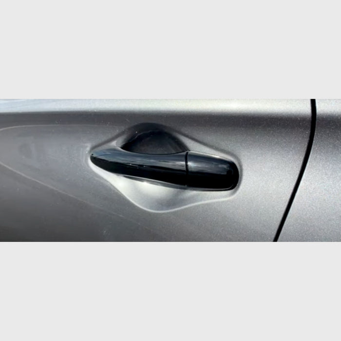 Close-up of a black car door handle on a silver car