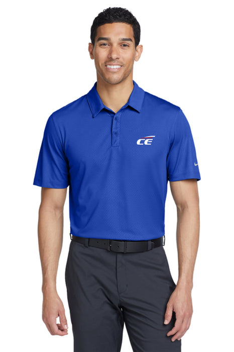 Man wearing a blue Nike Chrome Enhancments polo shirt and gray pants on a white background