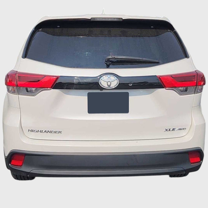 Back view of a white Toyota Highlander on a light gray background