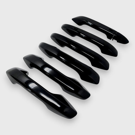Set of black car door handles arranged vertically on a white background