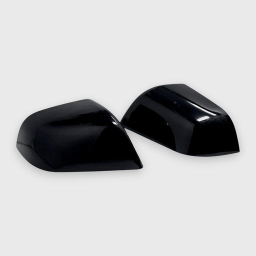 Two black car mirror covers on a white background