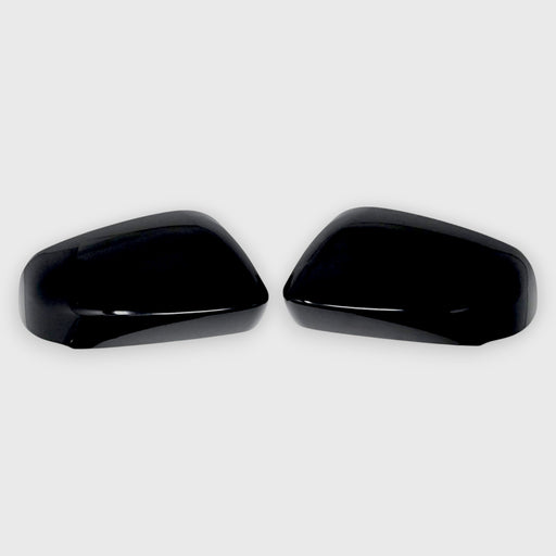 Two black Toyota car mirror covers on a white background