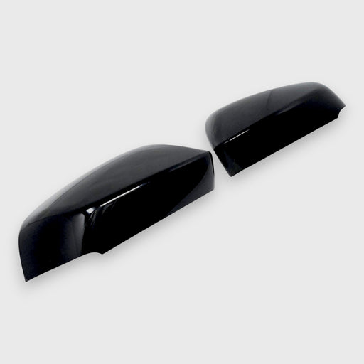 Two black Toyota car mirror covers on a white background