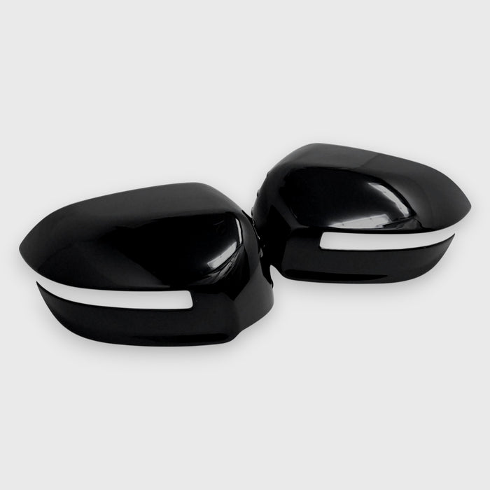 Black car mirror covers with white trim on a light gray background